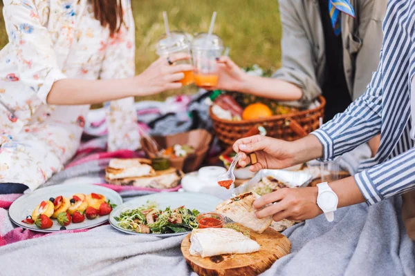 关闭女孩花时间在美丽的野餐与各种美味的食物和饮料在公园野餐毯 — 图库照片