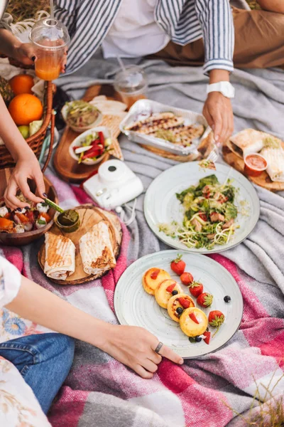 Güzel piknik ile çeşitli lezzetli yiyecekler ve içecekler üzerinde park piknik battaniyeye kadar kapatın