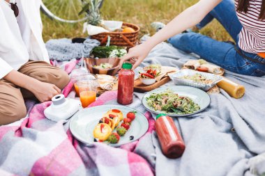 Piknik lezzetli yiyecek ve içecekler üzerinde park battaniyeye vakit kız fotoğraf kapatmak 