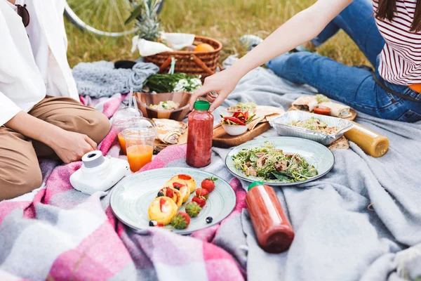 关闭图片的女孩花时间在野餐与美味的食物和饮料的毯子在公园 — 图库照片