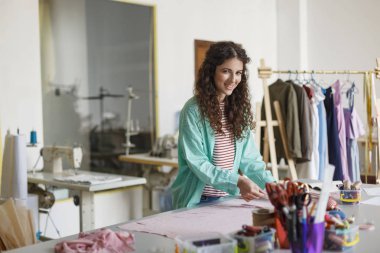 Güzel Moda Tasarımcısı mavi gömlek ve çizgili tişört mutlu rahat dikiş Atölyesi tekstilde çalışan kamera seyir 