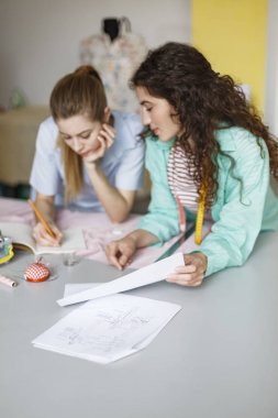 İki güzel tasarımcıları sersem dikiş Atölyesi yeni elbiseler çizimler birlikte çizim