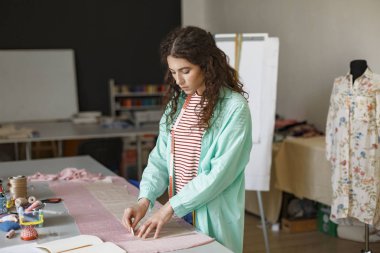 Genç düşünceli sabun ile modern dikiş atölyede çalışan tekstil çizim terzi