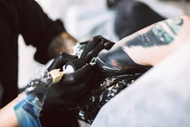 Siyah eldiven dövme dövme makinesi Studio'yu kullanarak istemci el işi profesyonel tattooer kadar kapatın