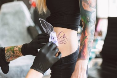 Tattooer siyah eldiven modern tattoo Studio kız vücudunda yeni dövme hazırlanıyor kapatın