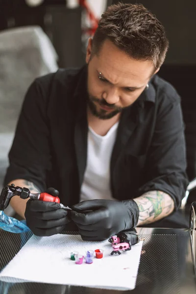 黒でプロの Tattooer 手袋タトゥー スタジオのカラフルなインクと仕事のための準備のタトゥー マシン — ストック写真