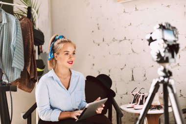 Genç güzellik blogger tablet içinde mutlu bir şekilde kayıt yeni moda video vlog için elele 