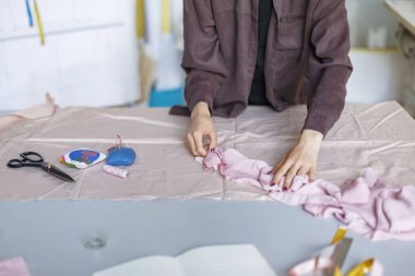Terzi kumaş modern dikiş atölyesinde çalışan gömlekli kapatın