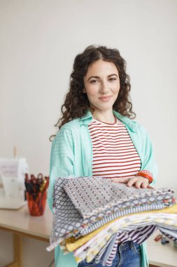 Sevinçle kamera dikiş Atölyesi elinde tutarak kalıpları kumaş arıyorum güzel gülümseyerek terzi