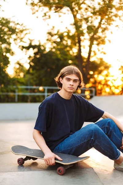 Mladí Bruslař Černé Tričko Džíny Zamyšleně Díval Fotoaparátu Skateboard Trávit — Stock fotografie