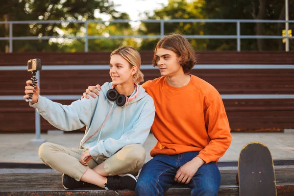 Ung Skejtare Pojke Och Flicka Med Hörlurar Nya Videoinspelning Glatt — Stockfoto