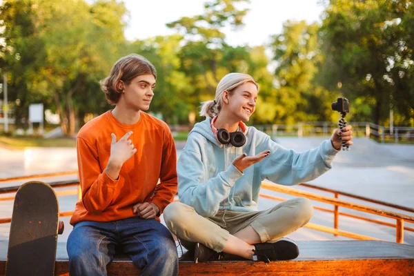 Νέοι Σκέιτερ Αγόρι Στο Πορτοκαλί Πουλόβερ Και Κορίτσι Ακουστικά Εγγραφή — Φωτογραφία Αρχείου