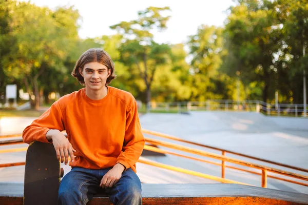 Joven Patinador Sonriente Jersey Naranja Mirando Alegremente Cámara Apoyada Monopatín — Foto de Stock