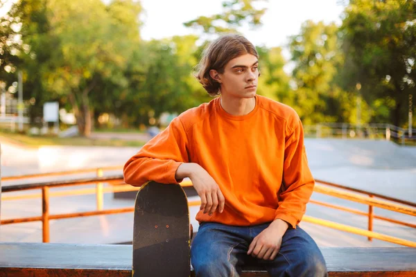 Jovem Patinador Pulôver Laranja Pensativo Olhando Para Lado Inclinado Skate — Fotografia de Stock