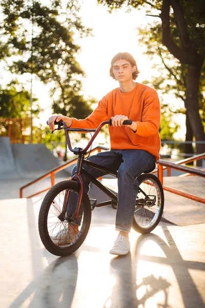 Pemuda Bercelana Jingga Dan Celana Jeans Duduk Atas Sepeda Dengan — Stok Foto
