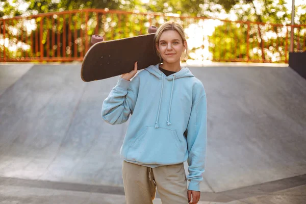 Πολύ Χαμογελαστό Κορίτσι Hoodie Κρατώντας Skateboard Στον Ώμο Απορώντας Βλέπουν — Φωτογραφία Αρχείου