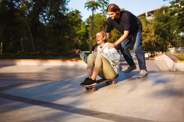 Αρκετά Χαρούμενο Κορίτσι Συνεδρίαση Για Skateboard Και Ιππασία Νεαρό Άντρα — Φωτογραφία Αρχείου