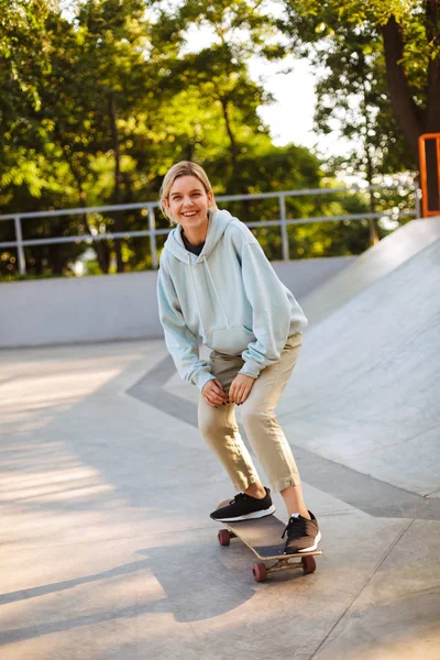 Veselá Dívka Hoodie Šťastně Pohledu Kamery Snaží Skateboardingu Moderní Skatepark — Stock fotografie