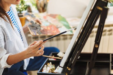 Palet rengi el evde tutan şövale üzerinde çizim ressam kapatın