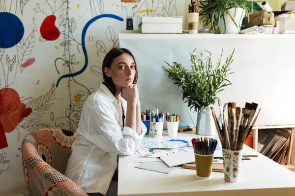 Young Painter White Shirt Desk Pictures Thoughtfully Looking Camera Creative — Stock Photo, Image