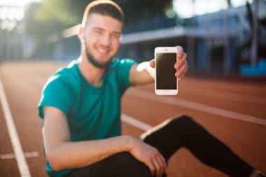 Yeni cep telefonu kamera vakit stadyum yarış pisti üzerinde gösteren adam kapatın