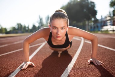 Güzel kız radyo earphones ve düşünceli seyir fotoğraf makinesindeki harcama zaman Stadyumu treadmill spor top