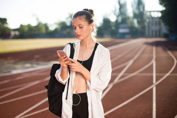 Bella Ragazza Auricolare Con Zaino Sulla Spalla Premurosamente Utilizzando Cellulare — Foto Stock