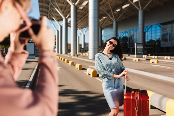 Menina Sorridente Óculos Sol Com Mala Vermelha Olhando Alegremente Câmera — Fotografia de Stock