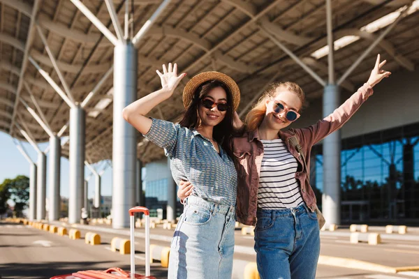 Duas Garotas Sorridentes Óculos Sol Alegremente Olhando Câmera Levantando Mãos — Fotografia de Stock