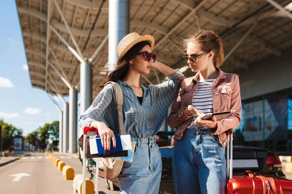 Young Female Friends Sunglasses Amazedly Looking Each Other Holding Passport — Stock Photo, Image