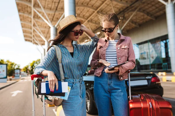 Jovens Amigas Óculos Sol Segurando Passaporte Com Bilhetes Pensativamente Usando — Fotografia de Stock