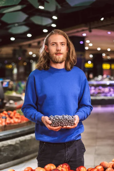 Jonge Kerel Donker Blauwe Trui Dromerig Kijken Camera Bedrijf Bosbessen — Stockfoto