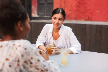 Arkadaş kafe avluda vakit sersem bakarak içki ile beyaz gömlek gülümseyen kız güzel