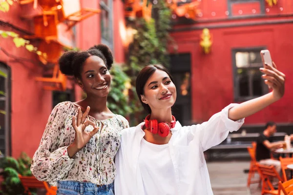 Kaksi Melko Tyylikäs Tytöt Ottavat Kuvia Matkapuhelimeen Onnellisesti Viettää Aikaa — kuvapankkivalokuva