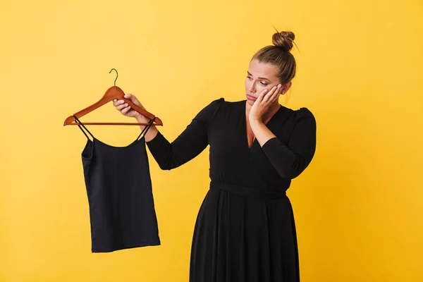 Young Woman Black Dress Thoughtfully Holding Hanger Black Top Yellow — Stock Photo, Image