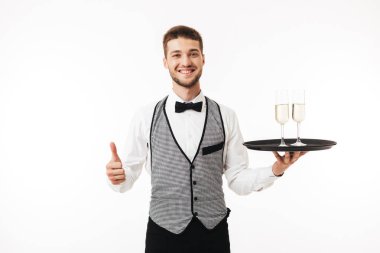 Mutlu bir şekilde kamera hareketi yukarı beyaz arka plan üzerinde gösterilen gözlüklü holding tepsi seyir üniformalı genç gülümseyen garson