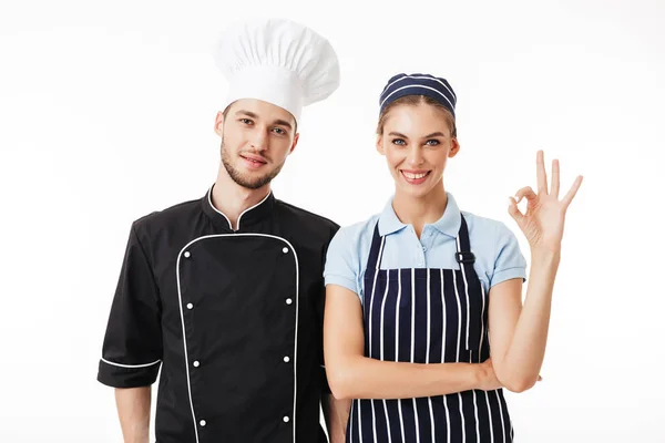 젊은이 검은색 유니폼에 요리사와 카메라 스트라이프 앞치마 요리와 제스처를 보여주는 — 스톡 사진