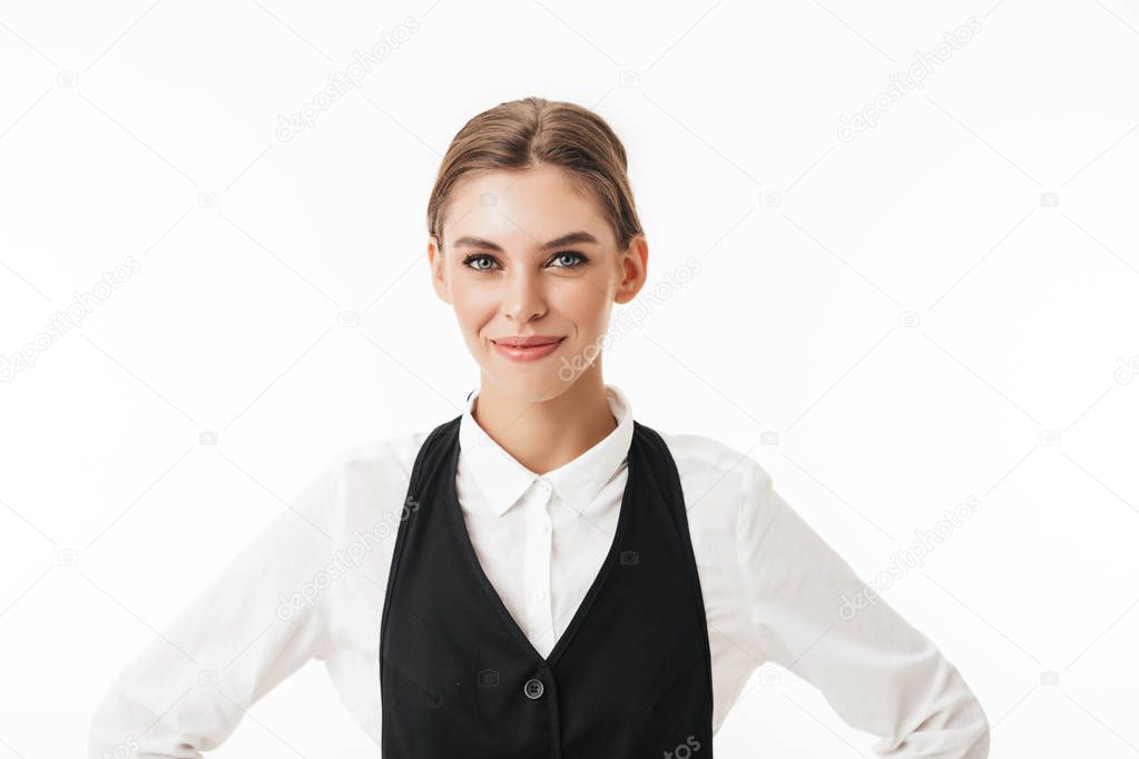 Young smiling woman in black vest and white shirt dreamily looking in camera over white background