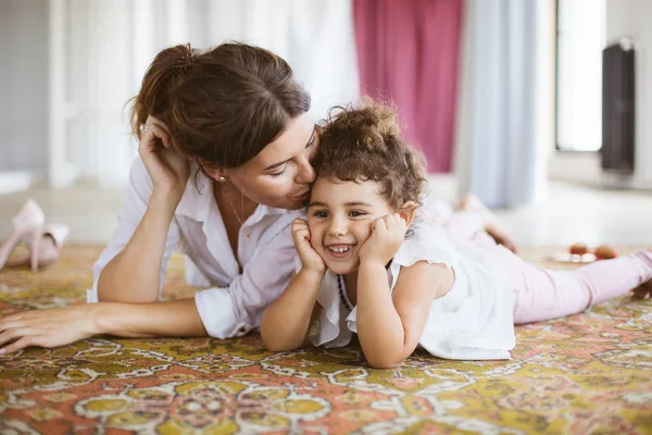 Güzel anne sersem mutlulukla birlikte evde vakit halı üzerinde yalan şirin küçük kızı öpüşme