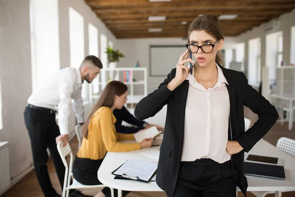 Genç Ciddi Kadını Gözlük Amazedly Bir Yana Office Cep Telefonu — Stok fotoğraf