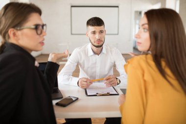 Genç modern ofiste vakit işverenler ne yazık ki bakarak Beyaz tişörtlü adam üzgün. Erkek başvuru bekleyen sonuçlarını iş görüşmesi
