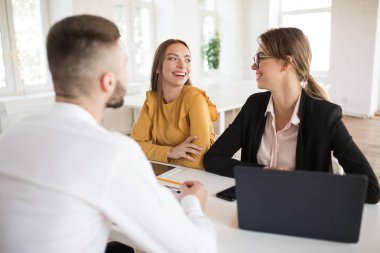 İki neşeli iş kadın mutlu bir şekilde birbirimize modern ofis iş görüşmesine harcama arıyor