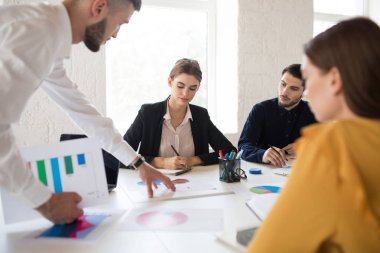 Grup birlikte yeni projede çalışan yaratıcı insan. Genç kız gömlek ve ceket düşünceli çalışma harcama zaman modern office 