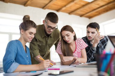 Grup iş erkek ve kadınların sersem iş vakit çizimler ile çalışma. Gençler yaratıcı modern ofis birlikte tartışarak yeni proje