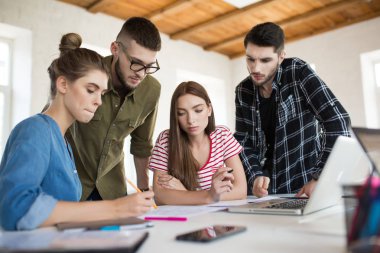 Grup iş erkek ve kadınların düşünceli işyerinde vakit çizimler ile çalışma. Gençler modern ofis birlikte yeni proje oluşturma
