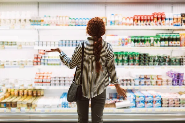 Mujer Joven Con Camisa Rayas Espalda Tratando Elegir Productos Lácteos —  Fotos de Stock