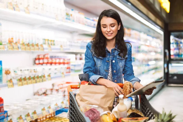 Усміхнена Дівчина Джинсовій Куртці Візком Повним Продуктів Тримають Планшет Руці — стокове фото