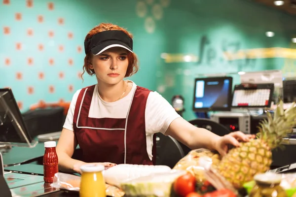 Jonge Boos Vrouwelijke Caissière Uniform Zorgvuldig Producten Werken Moderne Supermarkt — Stockfoto