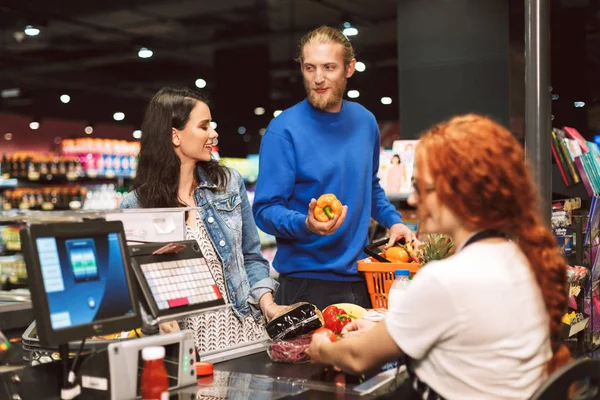 Young Smiling Couple Standing Cashier Desk Happily Buying Products Together — Stock Photo, Image