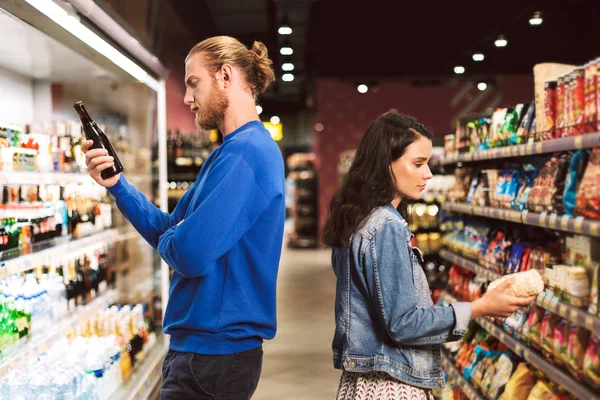 Young Thoughtful Couple Standing Back Back Choosing Products Spending Time — Stock Photo, Image